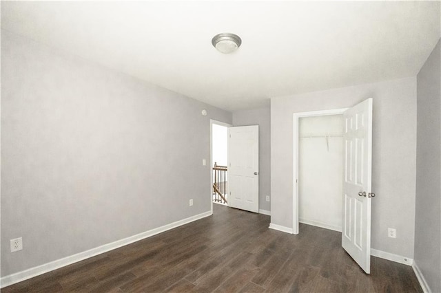 unfurnished bedroom featuring a closet and dark hardwood / wood-style floors