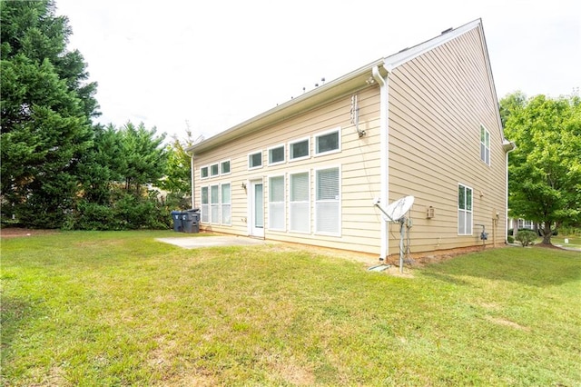 back of property with a lawn and a patio