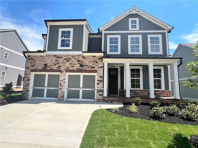 craftsman-style house featuring a front lawn, covered porch, and a garage