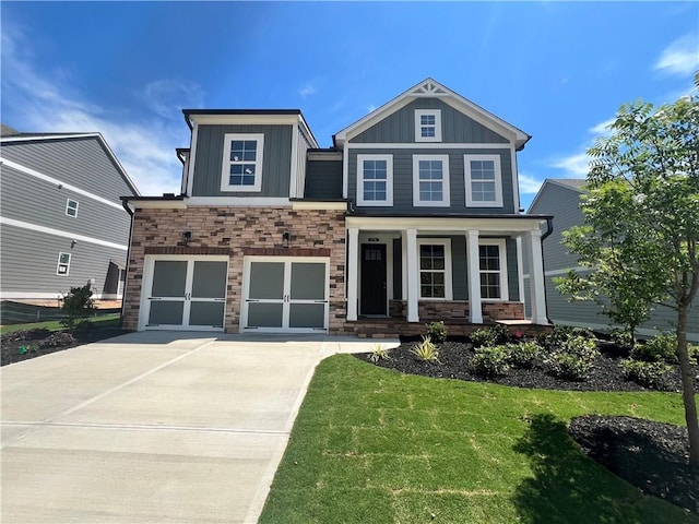 craftsman-style home featuring covered porch, a front yard, and a garage