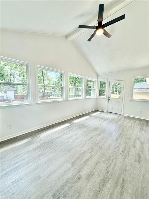 unfurnished sunroom featuring beamed ceiling