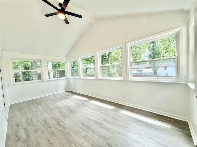 unfurnished sunroom featuring wood finished floors, baseboards, and a healthy amount of sunlight