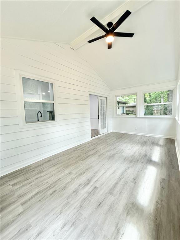 unfurnished sunroom featuring beamed ceiling
