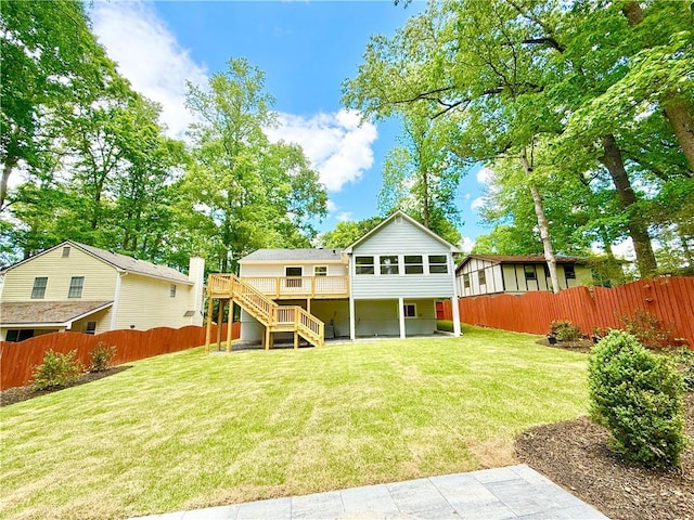 back of property with stairway, a deck, a lawn, and a fenced backyard