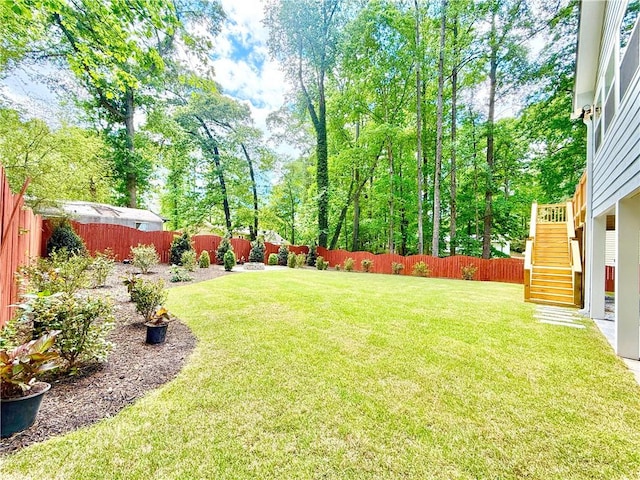 view of yard with stairs and a fenced backyard
