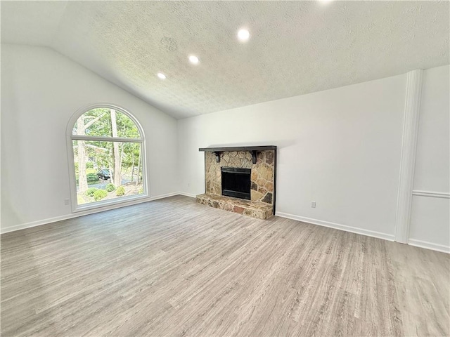 unfurnished living room with recessed lighting, a textured ceiling, baseboards, vaulted ceiling, and wood finished floors