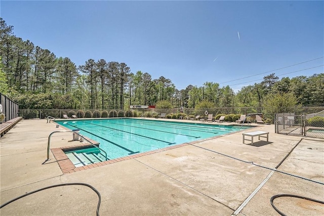community pool with fence and a patio area