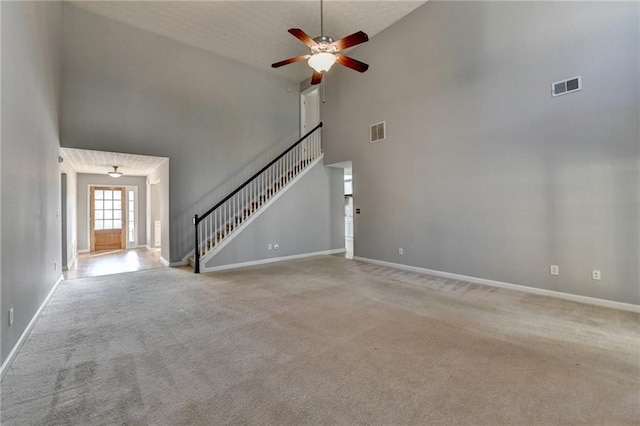 unfurnished living room featuring stairs, carpet, and visible vents