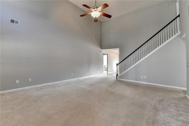 unfurnished living room with carpet floors, visible vents, stairway, ceiling fan, and baseboards