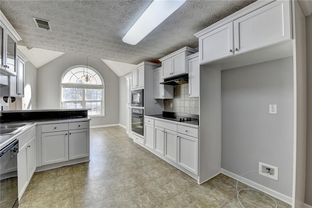 kitchen with visible vents, vaulted ceiling, a peninsula, under cabinet range hood, and black appliances