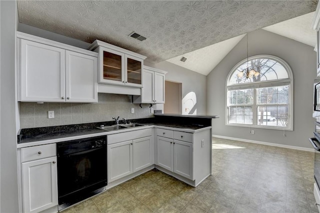 kitchen with visible vents, dishwasher, a peninsula, vaulted ceiling, and a sink