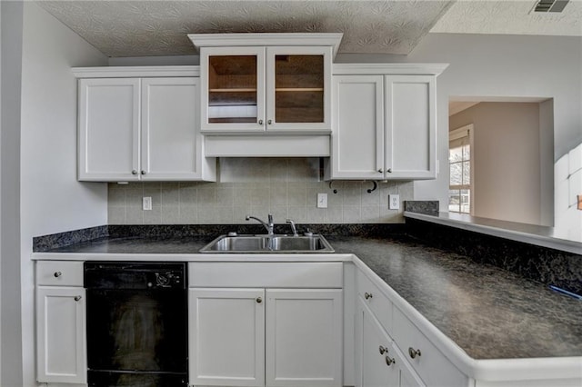 kitchen featuring black dishwasher, white cabinetry, decorative backsplash, and a sink