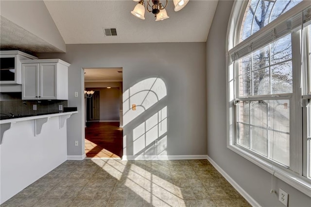 kitchen featuring plenty of natural light, visible vents, and a notable chandelier