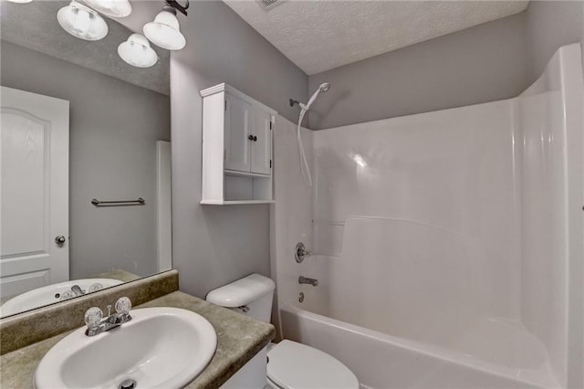 bathroom featuring shower / washtub combination, a textured ceiling, toilet, and vanity