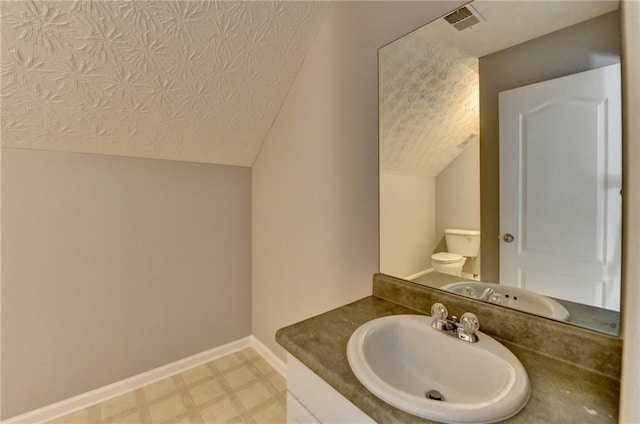 bathroom featuring lofted ceiling, visible vents, toilet, a textured ceiling, and baseboards