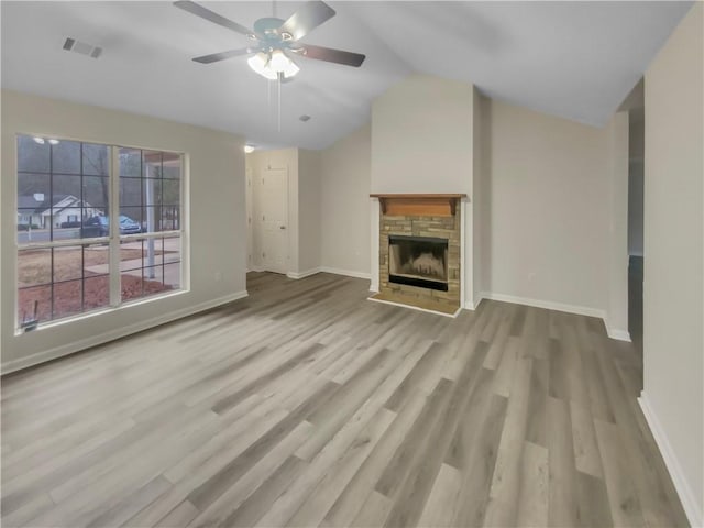 unfurnished living room featuring baseboards, visible vents, lofted ceiling, light wood-style floors, and a fireplace