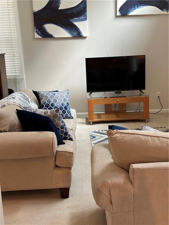 carpeted living room featuring baseboards