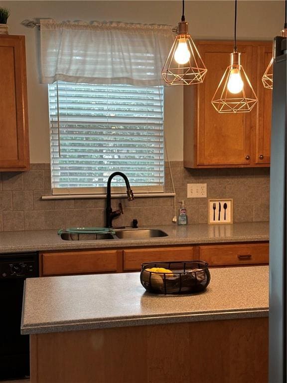 kitchen with backsplash, brown cabinetry, freestanding refrigerator, a sink, and dishwasher