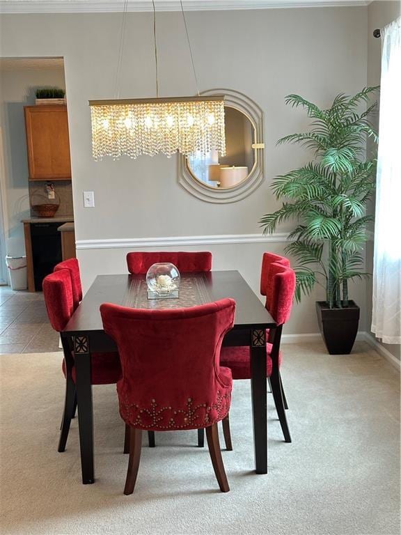 dining space featuring light carpet, light tile patterned floors, baseboards, and ornamental molding