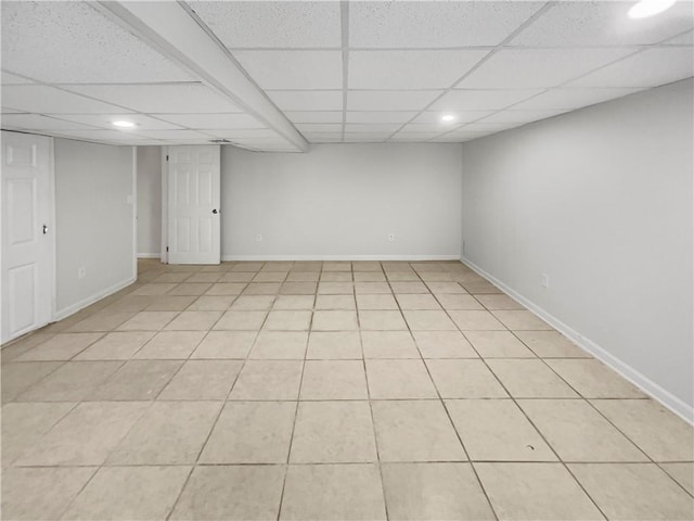 interior space featuring light tile patterned flooring and a paneled ceiling