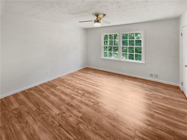 empty room featuring a textured ceiling, ceiling fan, and light hardwood / wood-style flooring