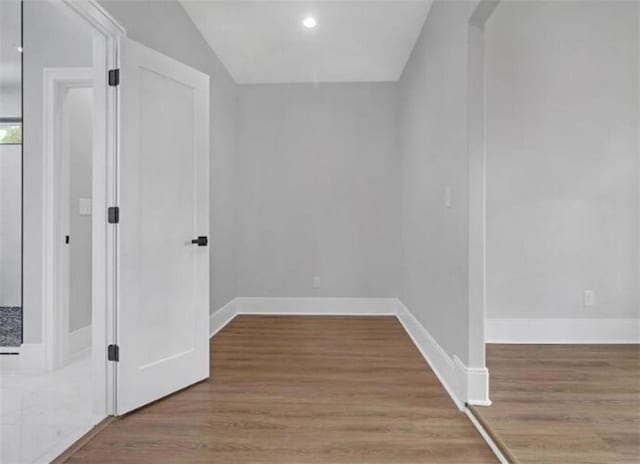 interior space with baseboards, recessed lighting, and wood finished floors