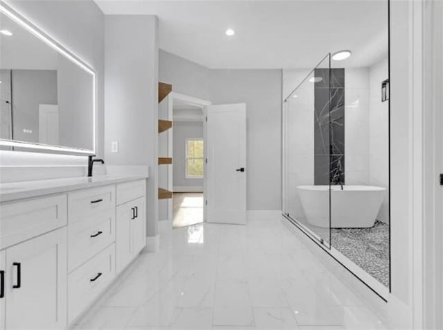 full bath with vanity, marble finish floor, baseboards, recessed lighting, and a freestanding bath