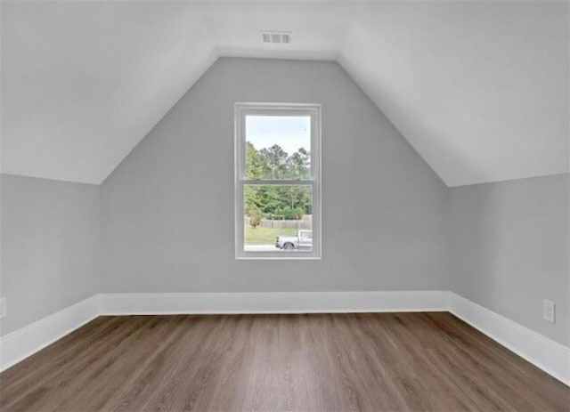 bonus room featuring visible vents, baseboards, lofted ceiling, and wood finished floors