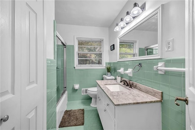 288 Valerie Cir, Hiram, GA 30141 - full bathroom with tile walls, tile patterned flooring, vanity, a wainscoted wall, and enclosed tub / shower combo