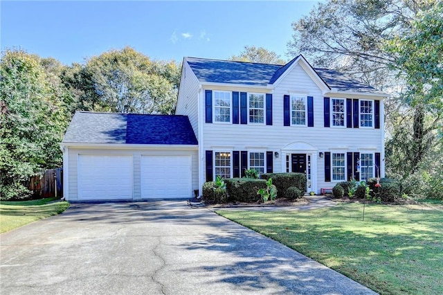 colonial home featuring a garage and a front lawn