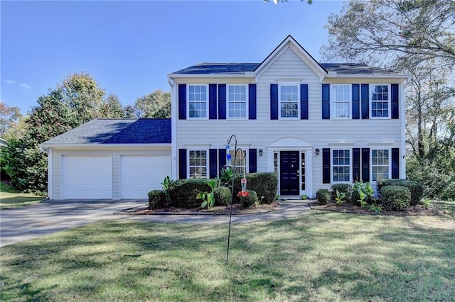 colonial inspired home with a garage and a front yard