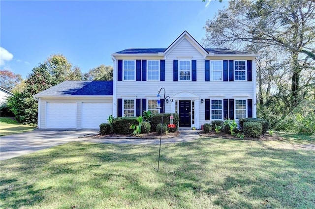 colonial inspired home with a garage and a front lawn