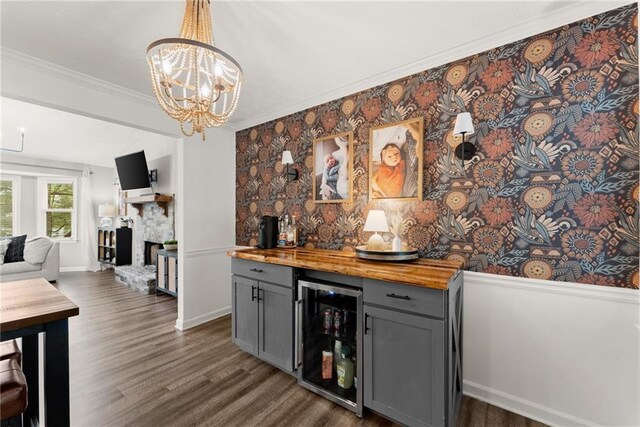 bar with a bar, a fireplace, dark wood-type flooring, and wine cooler