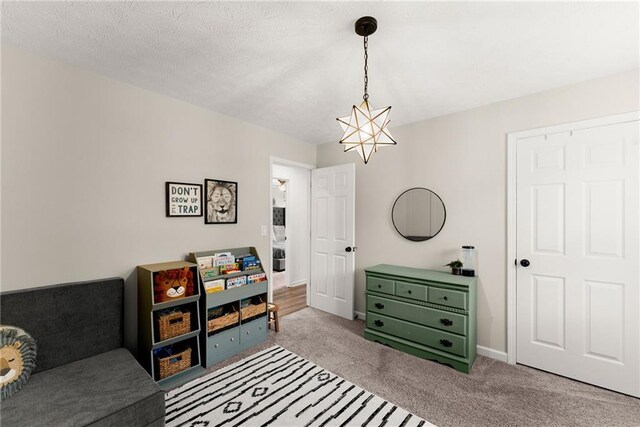 interior space featuring an inviting chandelier, baseboards, and carpet flooring