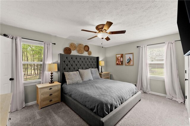 bedroom featuring baseboards, a ceiling fan, carpet, and a textured ceiling