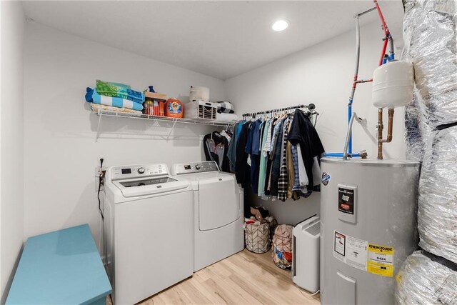 washroom with electric water heater, recessed lighting, laundry area, washer and dryer, and light wood finished floors