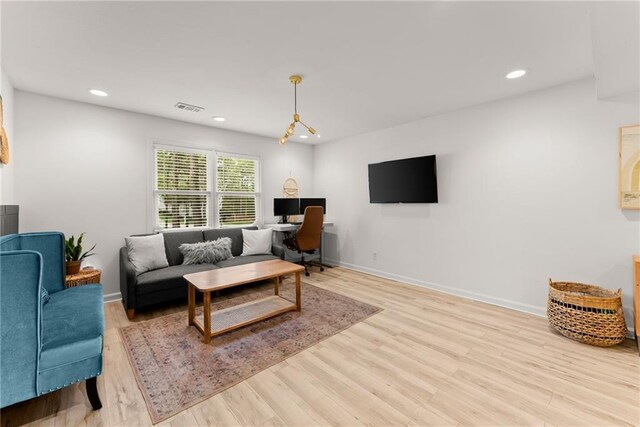 living room with visible vents, baseboards, recessed lighting, and light wood-style floors