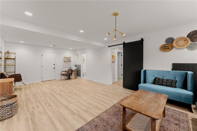 sitting room with light wood finished floors, baseboards, recessed lighting, and a barn door