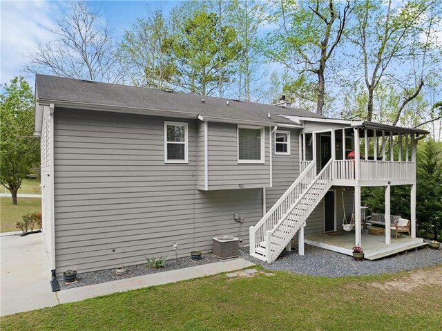 back of house with a chimney, stairs, a wooden deck, a yard, and a sunroom