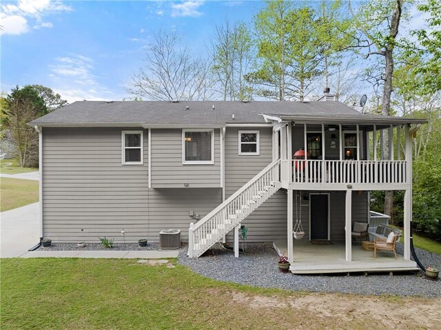 back of house with a wooden deck, a sunroom, a lawn, stairway, and central AC unit