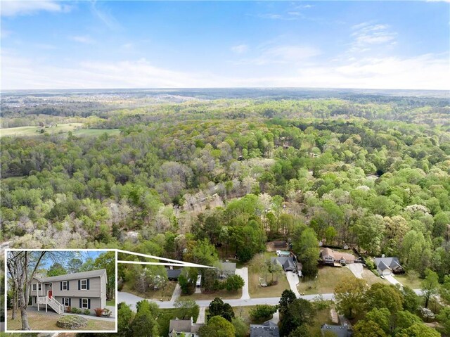 birds eye view of property featuring a wooded view