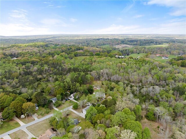 drone / aerial view with a wooded view