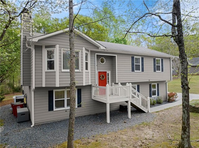 bi-level home featuring a wooden deck and a chimney