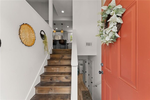 foyer entrance with visible vents, baseboards, stairway, recessed lighting, and wood finished floors