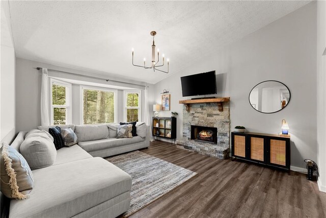 living area with an inviting chandelier, a textured ceiling, a stone fireplace, wood finished floors, and lofted ceiling