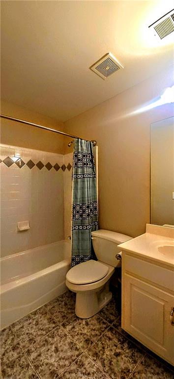 full bathroom featuring shower / bath combination with curtain, toilet, tile patterned floors, and visible vents