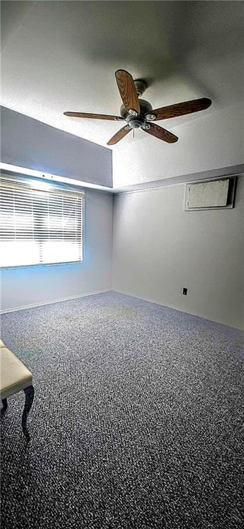 carpeted spare room featuring a ceiling fan