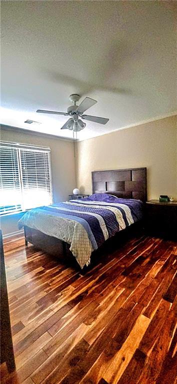 bedroom featuring wood-type flooring, a textured ceiling, and ceiling fan