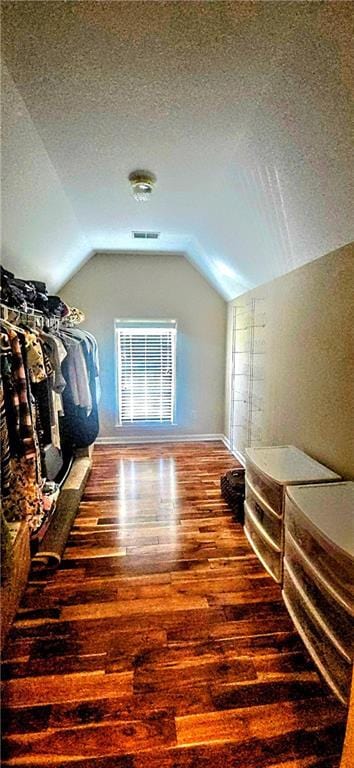 bonus room featuring vaulted ceiling, wood finished floors, a textured ceiling, baseboards, and visible vents