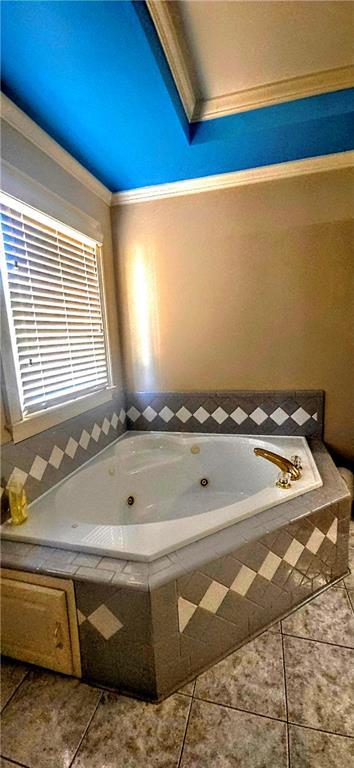 bathroom with ornamental molding, a tub with jets, and tile patterned floors